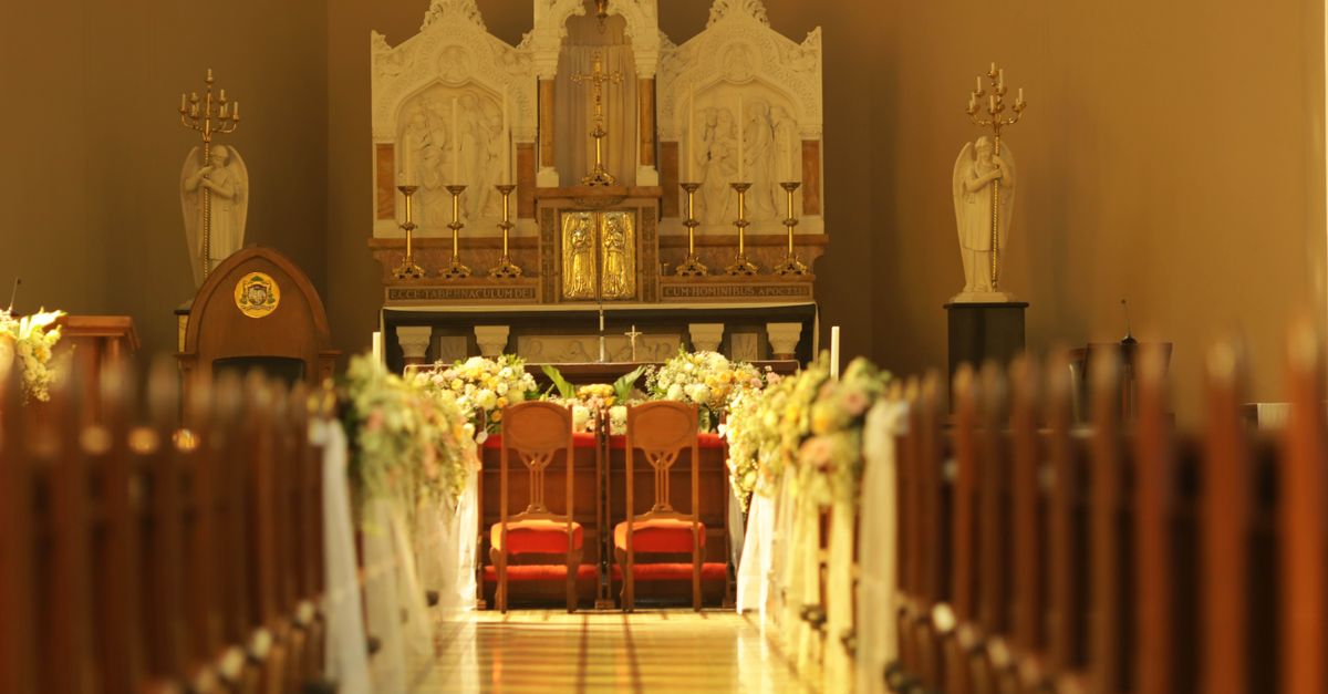 A beautifully decorated church interior with floral arrangements and ornate altar.